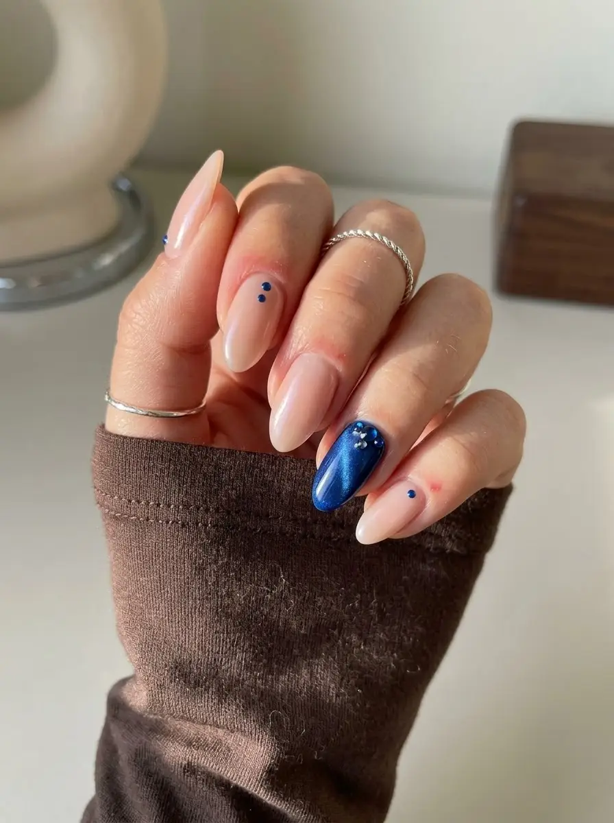 Blue Chrome Accent Birthday Nails - Sheer nude almond nails with cobalt blue dots and metallic blue chrome accent nail