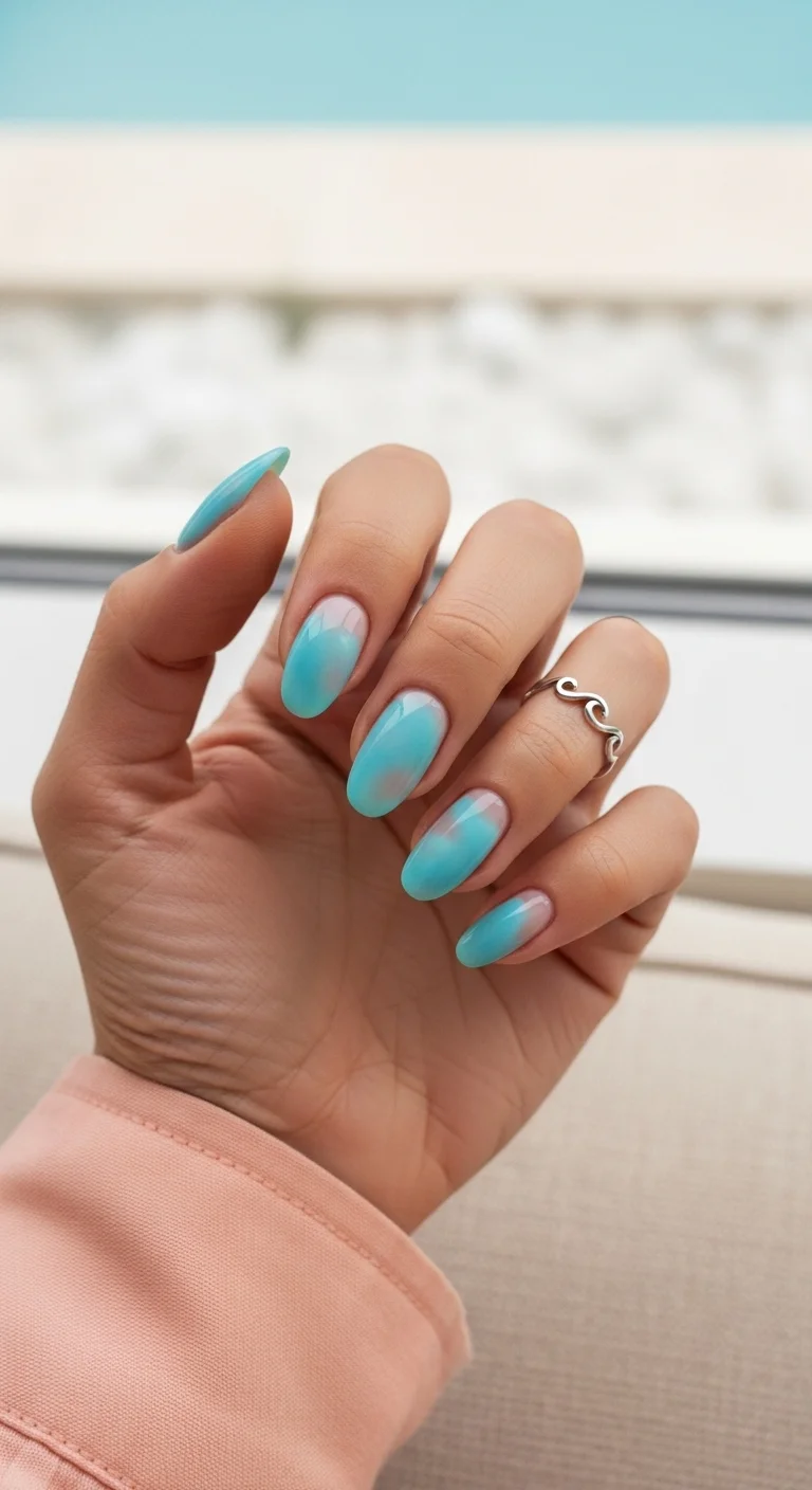 Almond nails with a blue-to-nude aura/gradient effect.