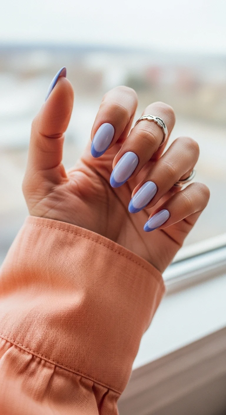 Almond nails with a soft lavender base and periwinkle blue French tips.