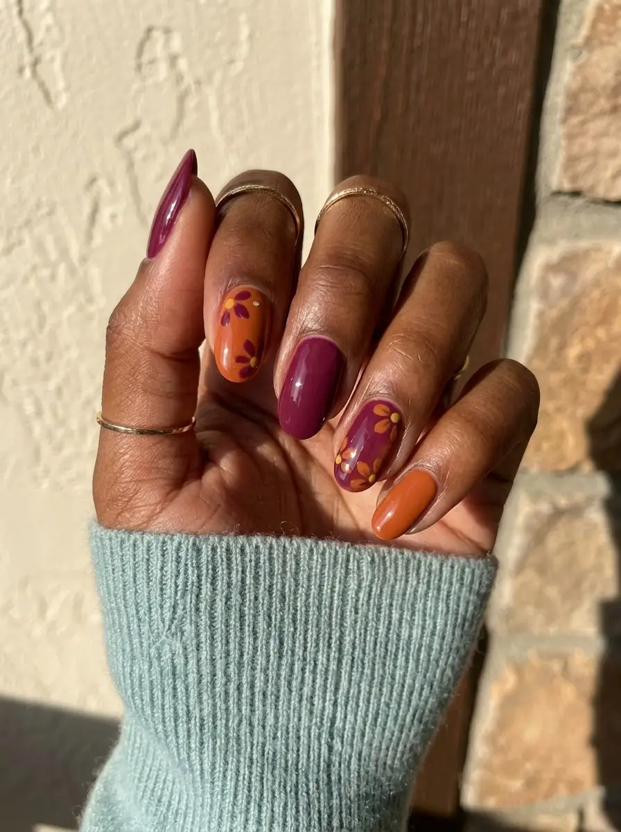 Deep Plum & Burnt Orange Floral Nails - Glossy deep berry-plum nails alternating with saturated burnt orange and hand-painted floral details