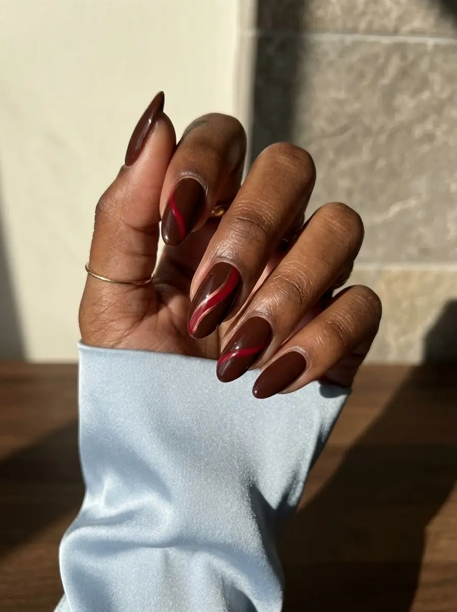 Chocolate Brown & Red Swirl Nails - Glossy deep chocolate brown almond nails accented with vivid crimson red swirl lines