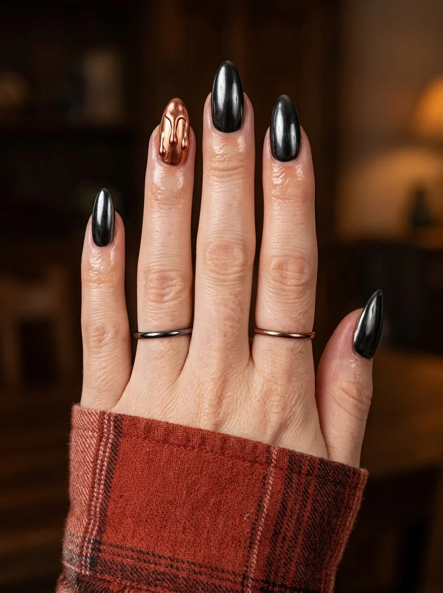 Long almond nails with a dark gunmetal black chrome finish and a rose gold copper drip accent nail.