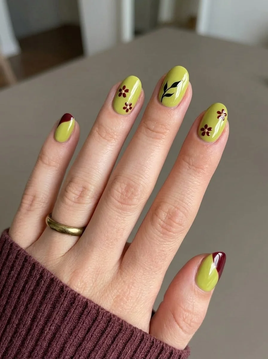 Olive green nails with red floral accents and burgundy french tips