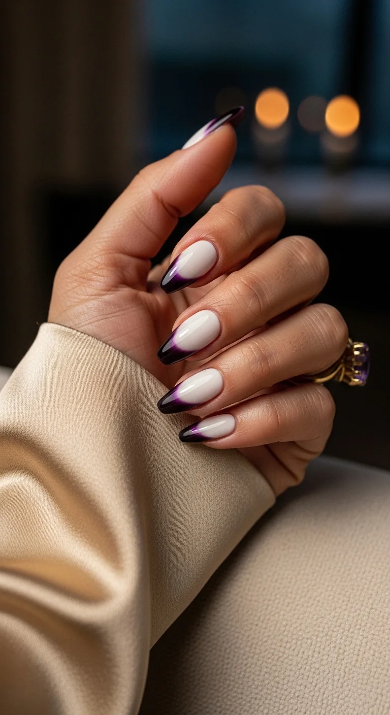 Long almond nails with a nude base and deep purple to black gradient tips.