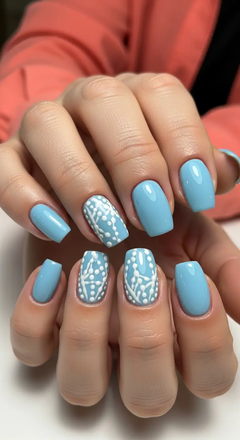 Light blue short squoval nails with intricate white dotted mandala and lace patterns